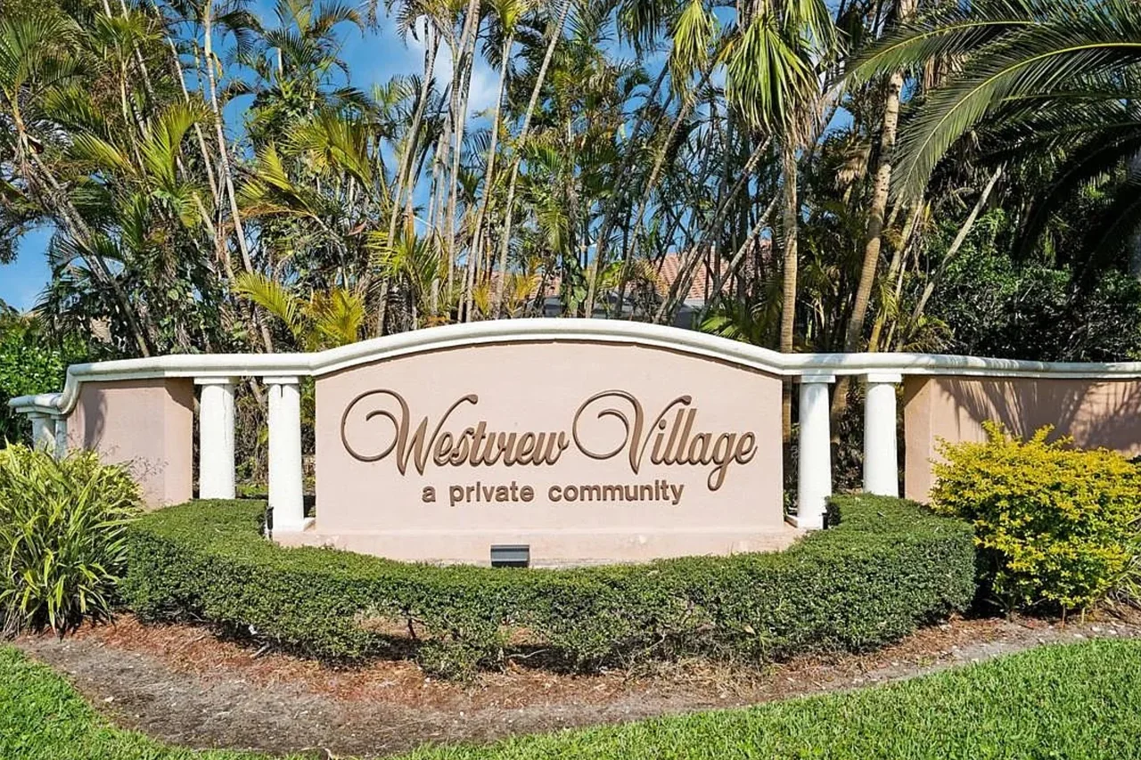 The Westview Village entrance sign surrounded by palms and landscaping